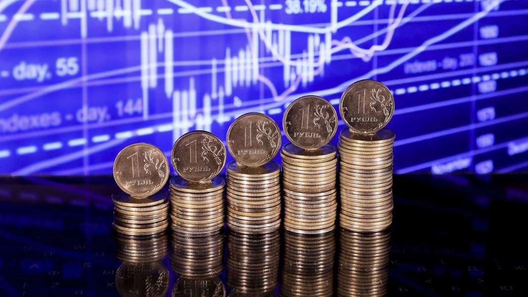 Монеты рубли на фоне графиков