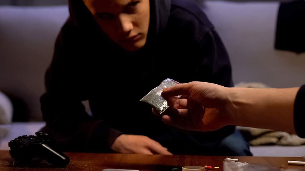 Подросток передает другому подростку пакетик с наркотическим веществом