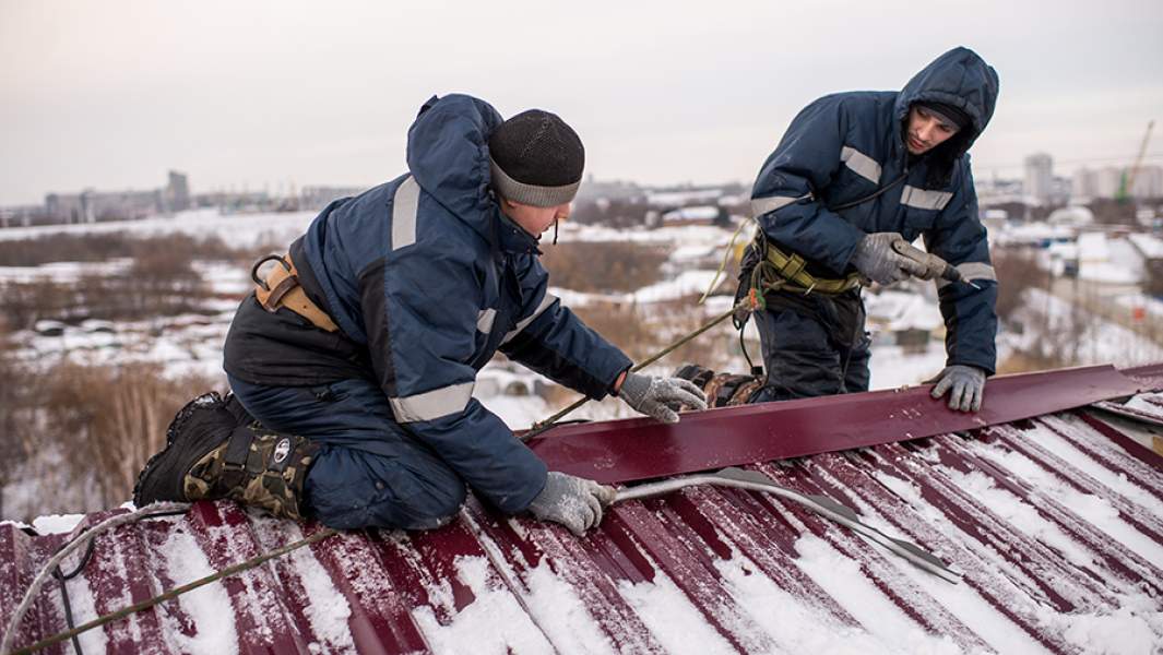 Рабочие регионального фонда капитального ремонта многоквартирных домов ремонтируют крышу жилого дома