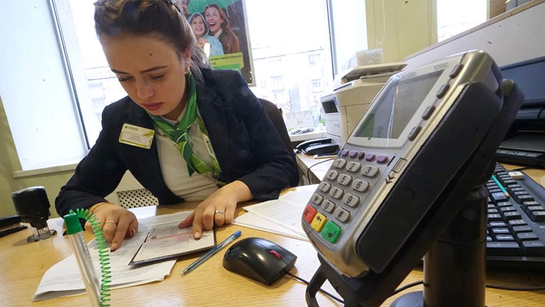 Сотрудница банка во время работы с клиентом