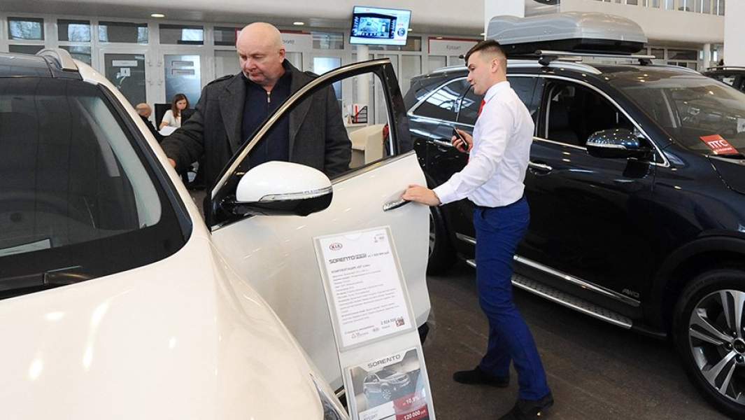 Сотрудник рассказывает клиенту о технических характеристиках автомобиля