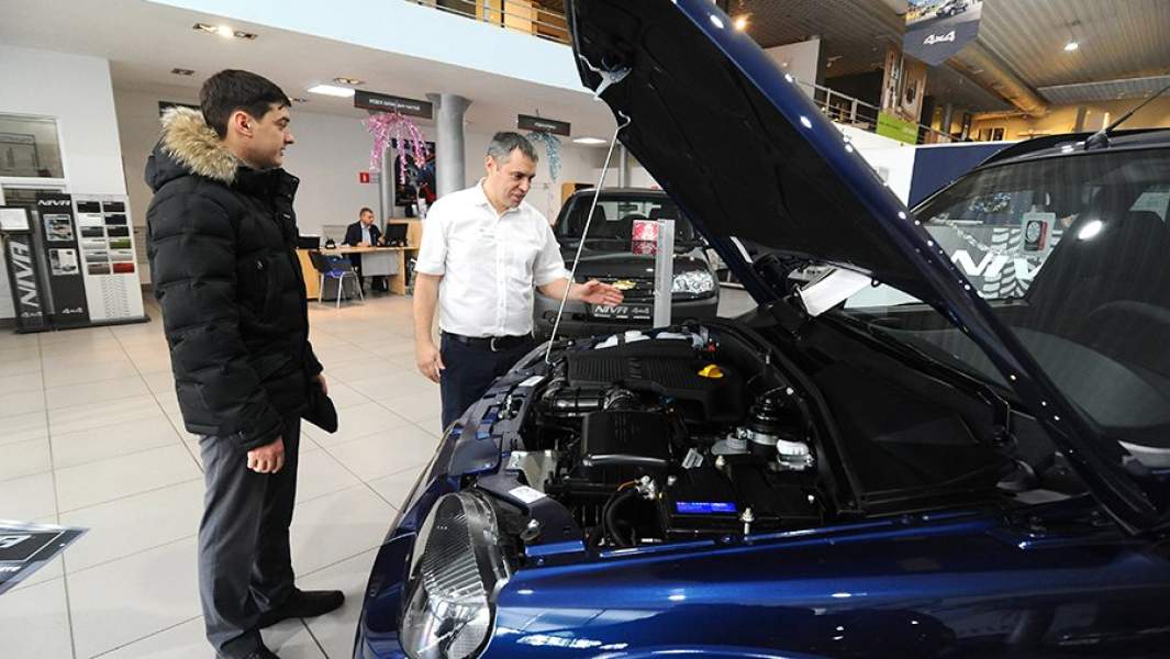 Сотрудник рассказывает клиенту о технических характеристиках автомобиля