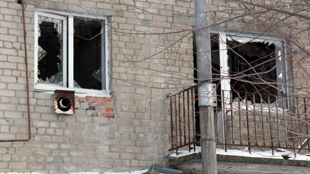 Разбитые в результате обстрела окна жилого дома в селе Спартак на севере Донецка