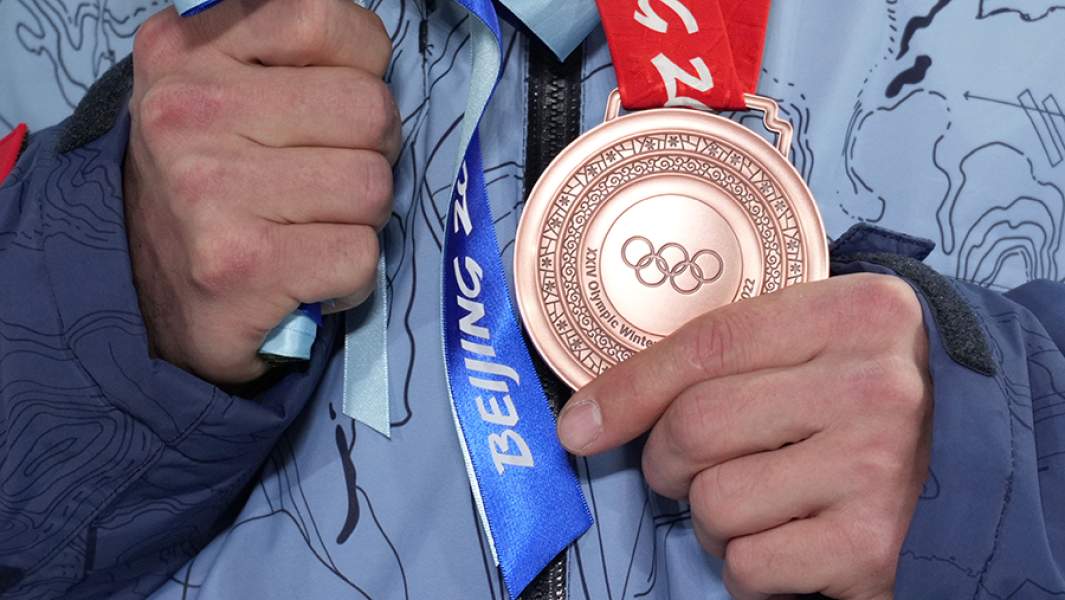 Бронзовая медаль в руках российского спортсмена, члена команды ОКР Виктора Уайлда, занявшего третье место на соревнованиях по сноуборду в дисциплине параллельный гигантский слалом среди мужчин на XXIV зимних Олимпийских играх 2022