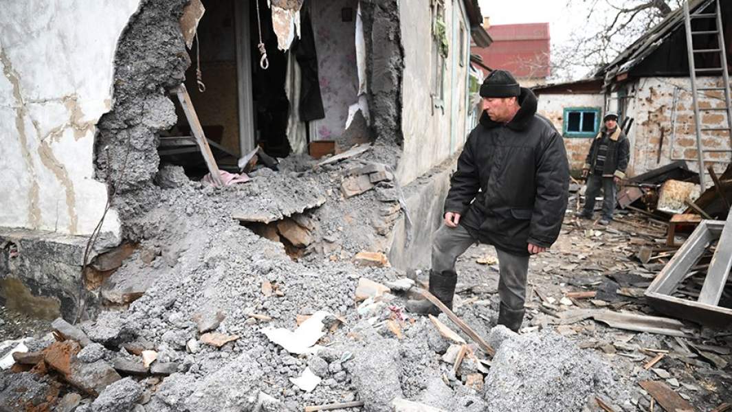 Мужчины возле дома, разрушенного после обстрела поселка Зайцево в Горловке