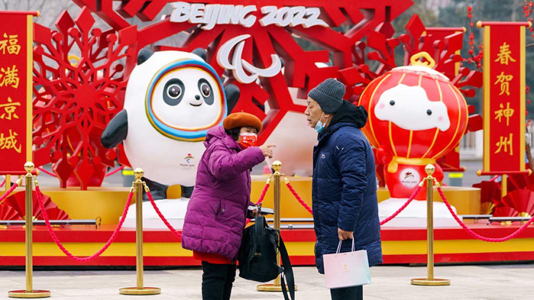 Мужчина и женщина возле инсталляции с символикой Олимпиады-2022