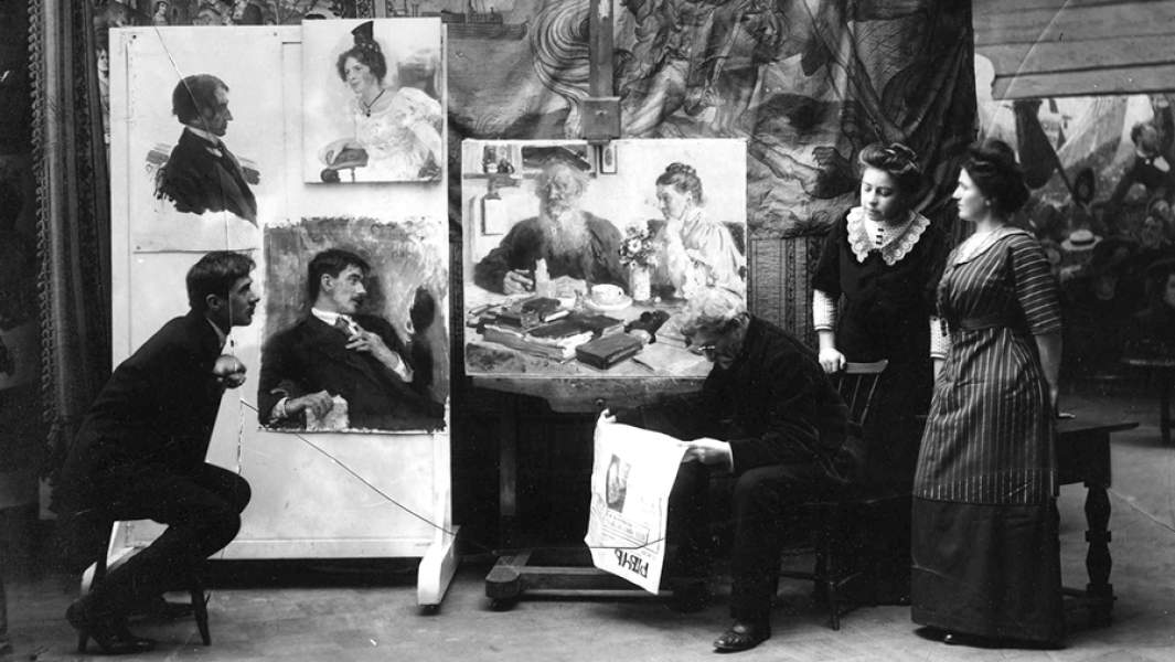 Чуковский (сидит слева) в студии Ильи Репина. Куоккала, ноябрь 1910 года. Репин читает сообщение о смерти Толстого. На стене виден неоконченный портрет Чуковского. Фотография Карла Буллы