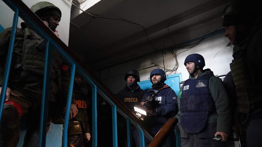 Журналисты в подъезде жилого дома во время обстрела Мариуполя