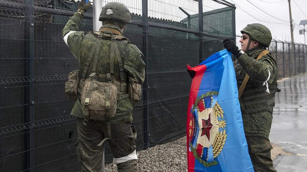 Военнослужащие народной милиции ЛНР поднимают флаг Луганской народной республики