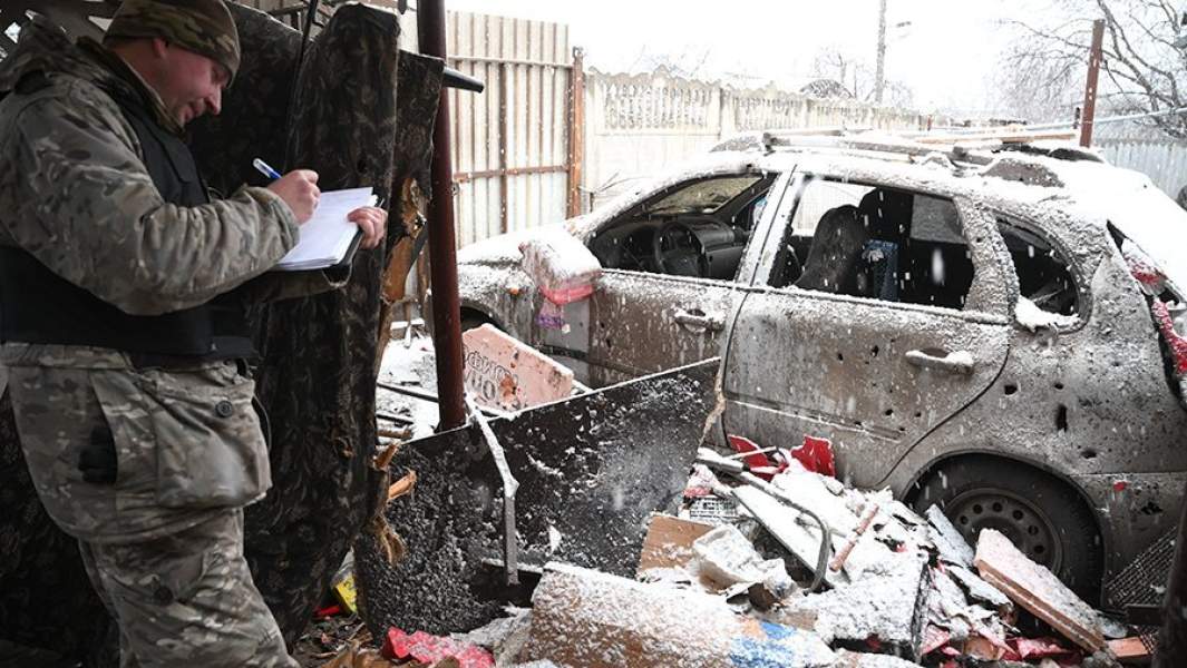 Следователь осматривает поврежденный в результате обстрела дом в Киевском районе Донецка