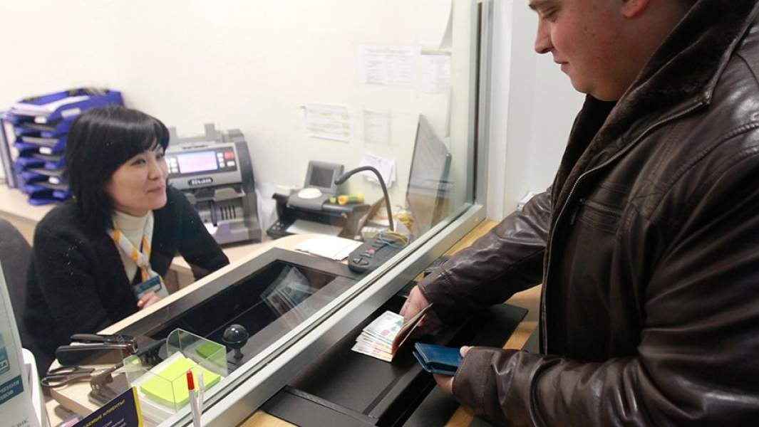 Мужчина вносит деньги на свой банковский счет