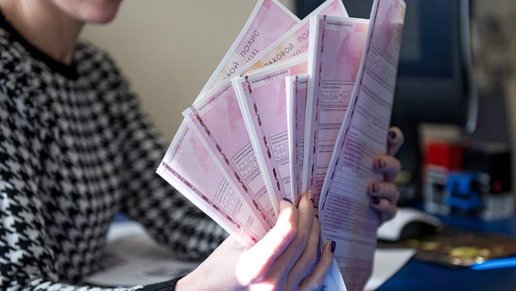 Сотрудник страховой компании демонстрирует страховой полис ОСАГО