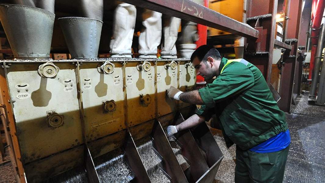 Рабочий регулирует семеновеечную машину в маслопрессовом цехе комбината в Тамбовской области