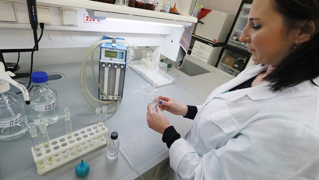 Сотрудник проводит анализ проб воздуха в лаборатории 