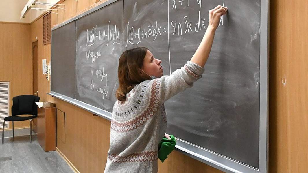 Преподаватель читает лекцию по физике студентам института