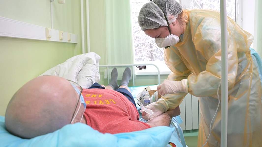 Медсестра вводит пациенту радиоактивный фармацевтический препарат для лечения онкологических заболеваний