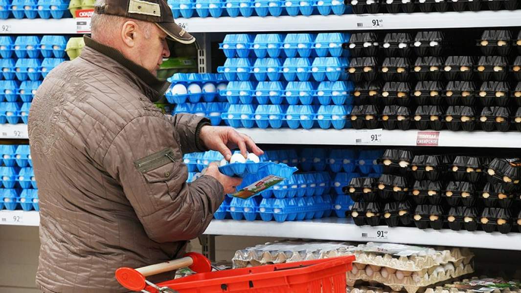 Покупатель выбирает куриные яйца в супермаркете