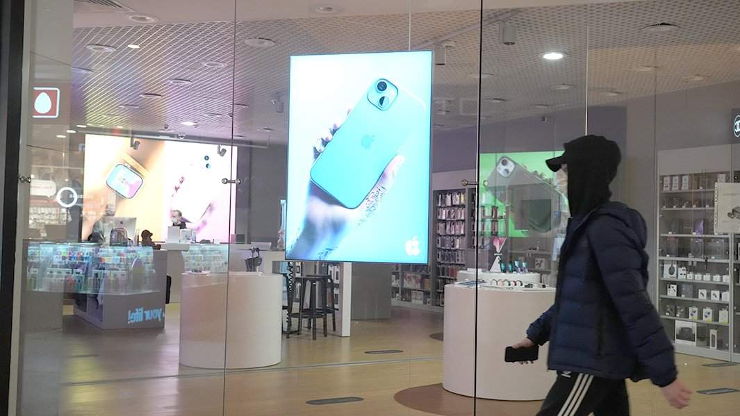 Человек идет мимо магазина