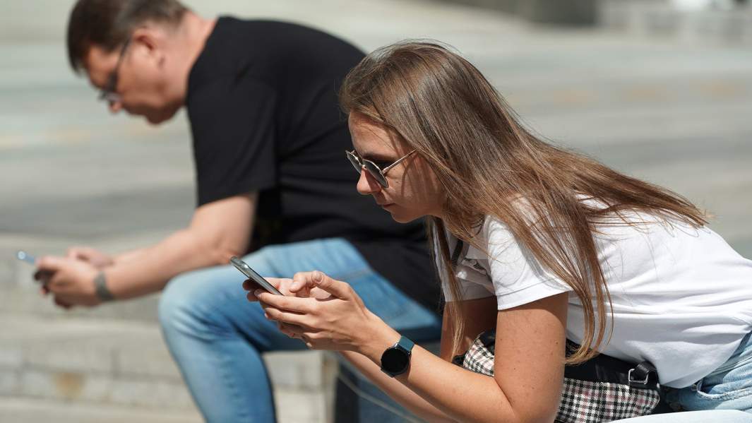 Мужчина и девушка со смартфонами