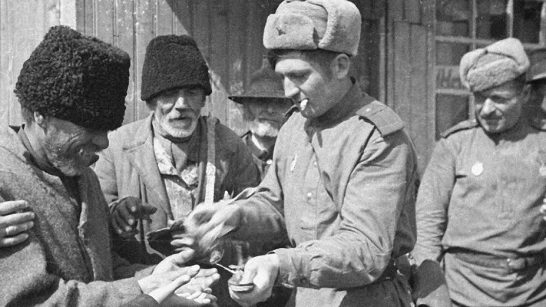 Солдаты угощают местных жителей махоркой