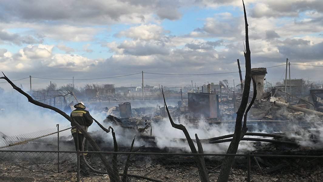 Сотрудник МЧС тушит пожар в Называевске Омской области. Пожар начался с открытого горения и распространился на жилые дома из-за сильного ветра – 29 домов сгорели полностью