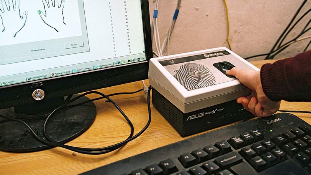 канер, снимающий рисунок большого пальца нового ученика