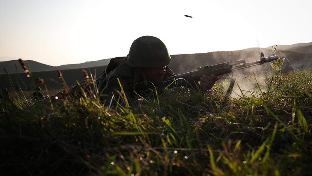 Военнослужащий ВС РФ стреляет из травы