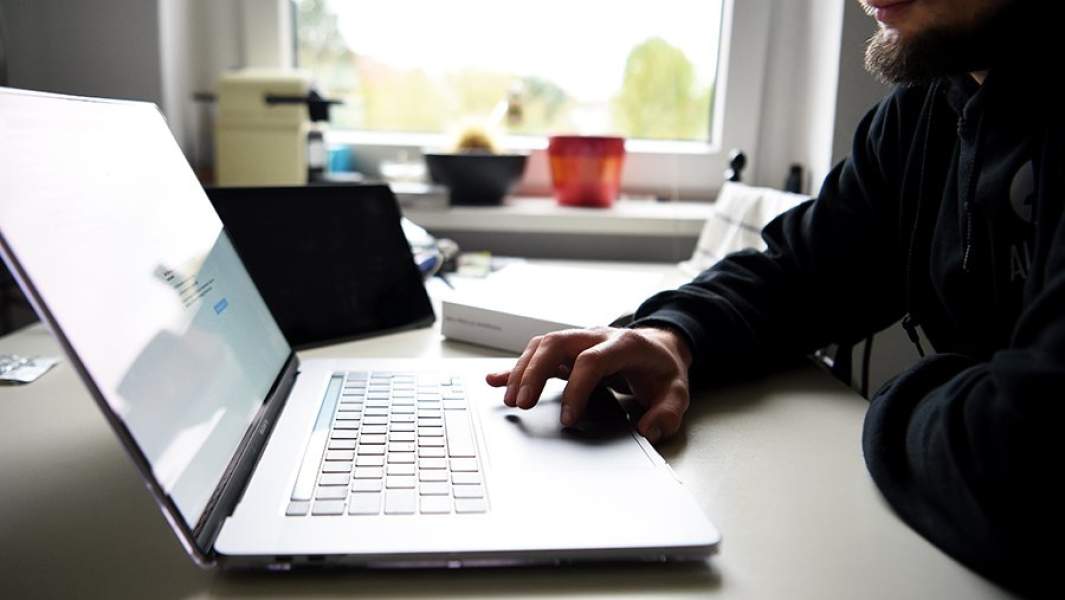 Человек сидит за столом с компьютером