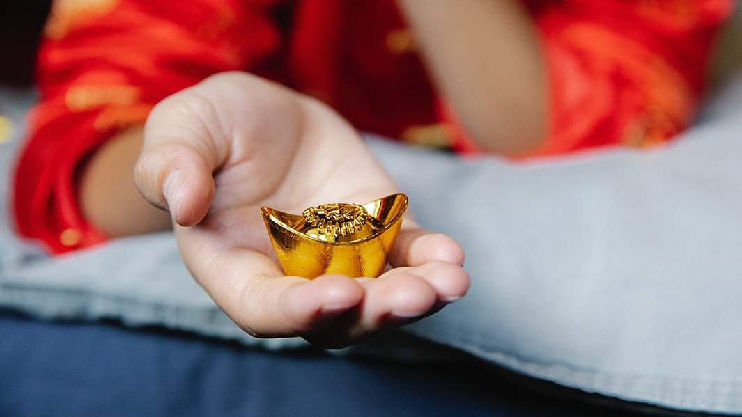 золотая статуэтка в руке