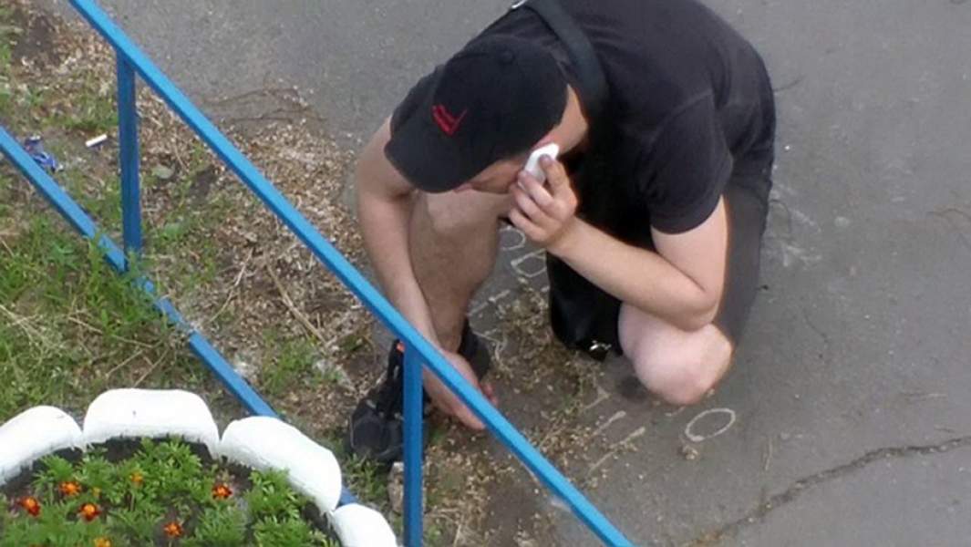 Подросток ищет закладку во дворе жилого дома. Кадр с камеры видеонаблюдения