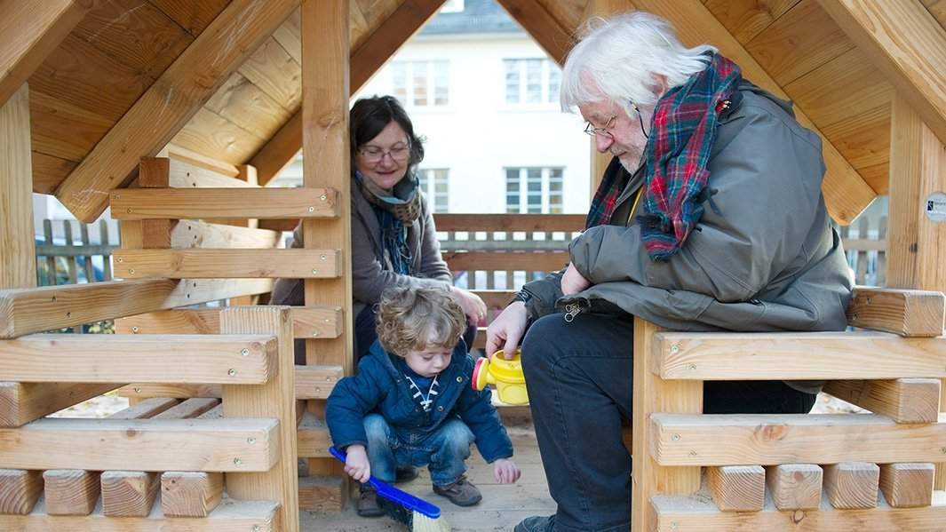 Пожилая пара играет с внуком
