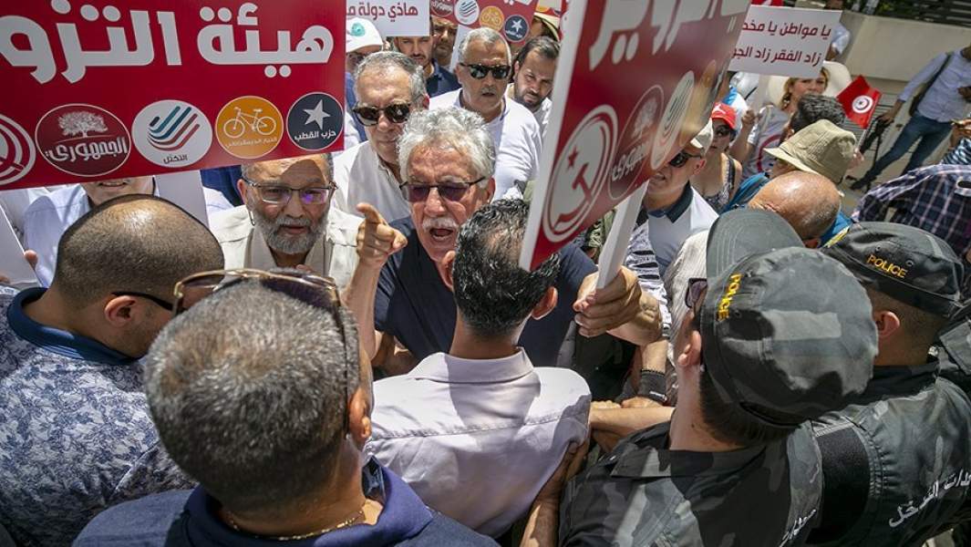 Сотрудники полиции преградили путь демонстрантам к зданию Независимого высшего избирательного совета Туниса во время акции протеста в ответ на указ президента Туниса Кайса Саида о новом конституционном референдуме в Тунисе