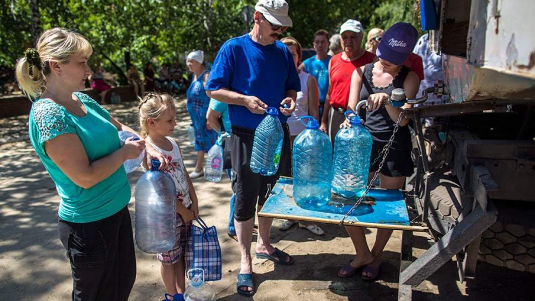Местные жители набирают воду из цистерны