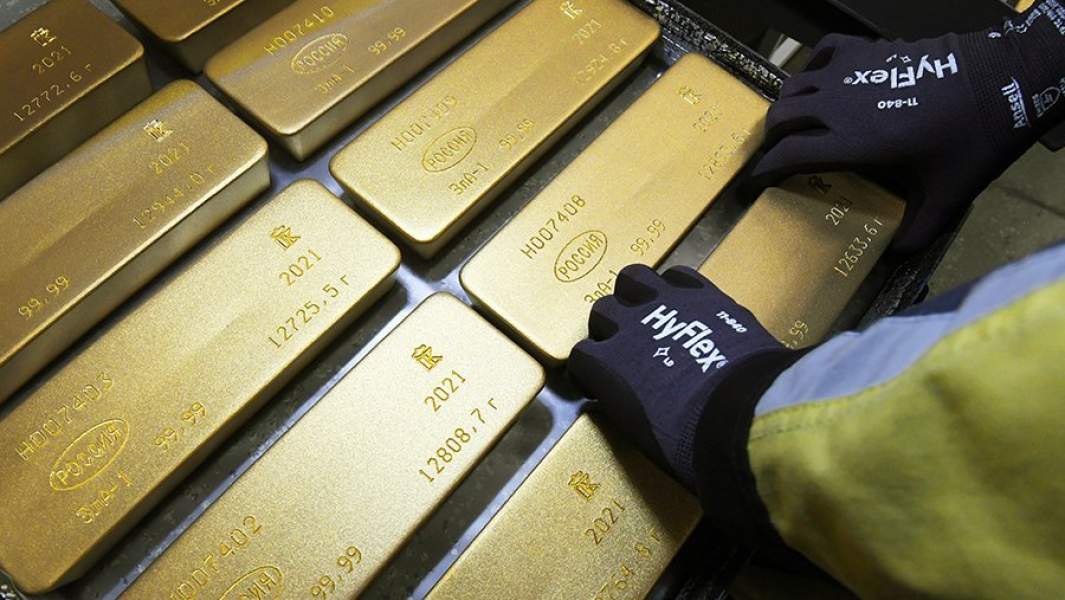 Сотрудник укладывает на тележку маркированные слитки золота