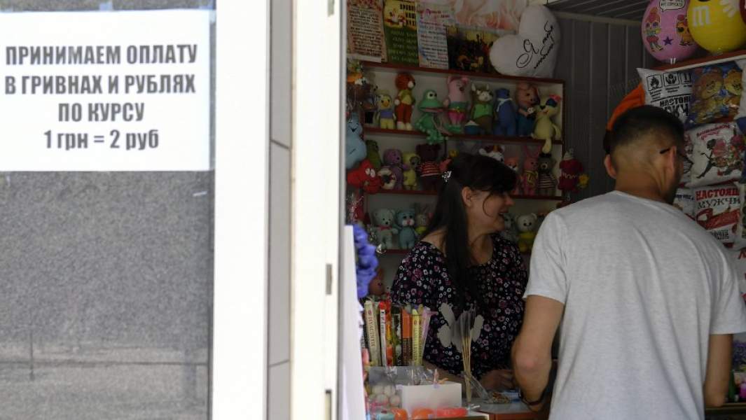 Объявление о возможности оплаты в гривнах и рублях у входа в сувенирный магазин в Бердянске