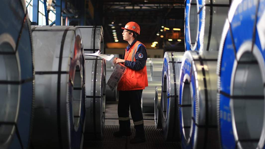 Рабочий во время маркировки проката холоднокатаного в рулонах в листопрокатном цеху