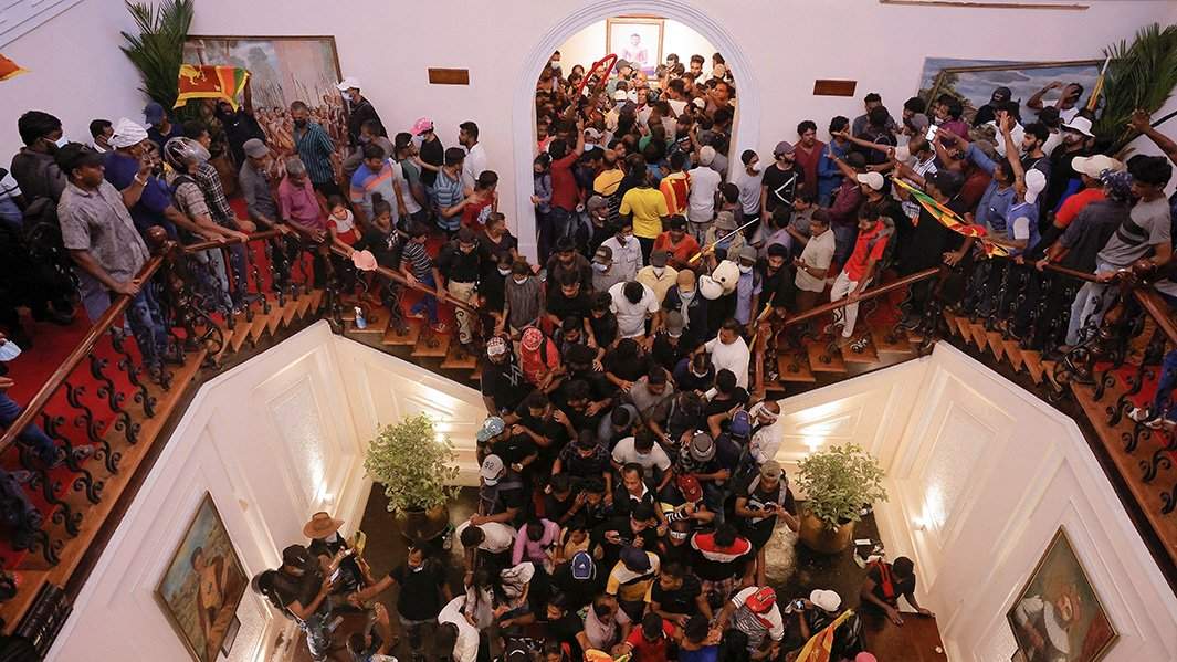 Демонстранты протестуют в Доме президента после бегства президента Готабая Раджапакса в Коломбо