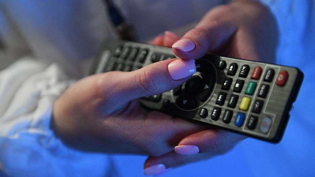 Пульт от телевизора в руках девушки