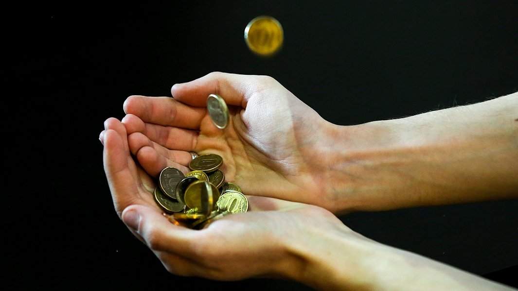 человек держит в руках российские монеты