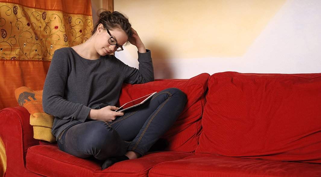 Девушка смотрит в монитор планшета