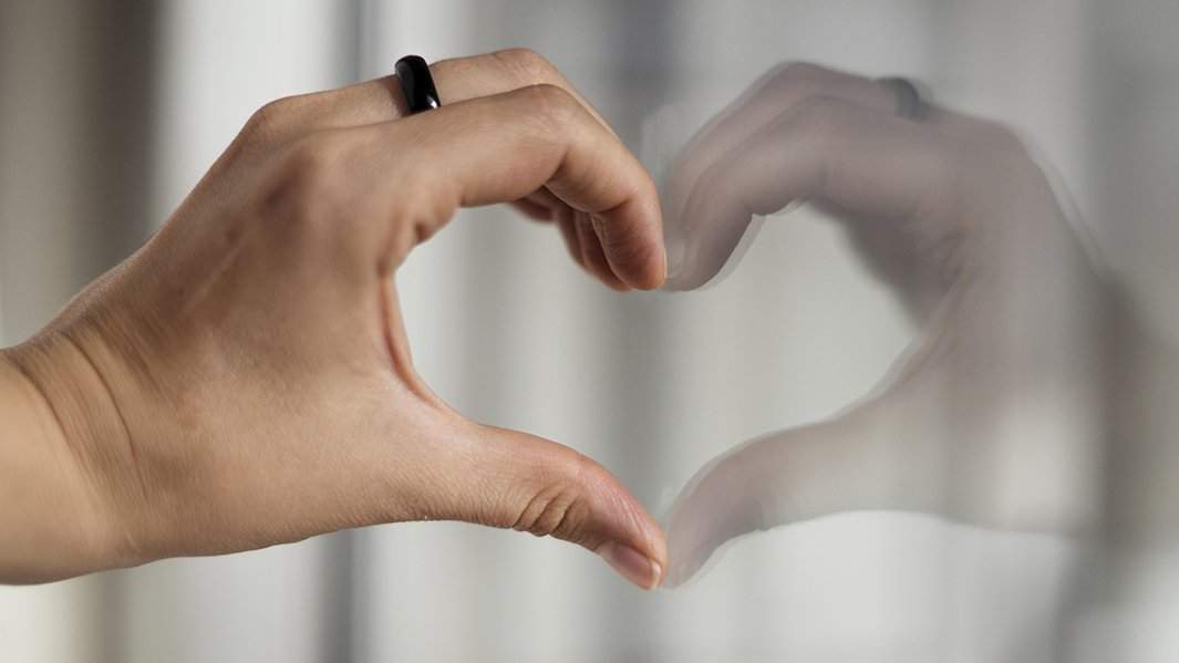 руки сложены сердечком на фоне неба