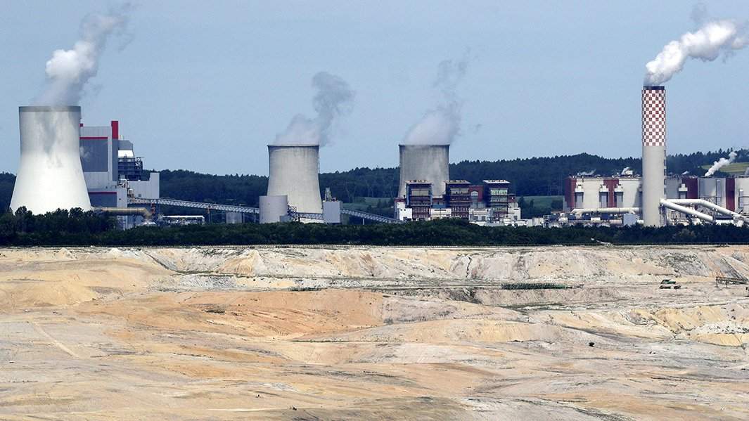 угольная электростанция видна позади угольного карьера