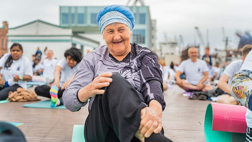 Пожилая женщина занимается йогой