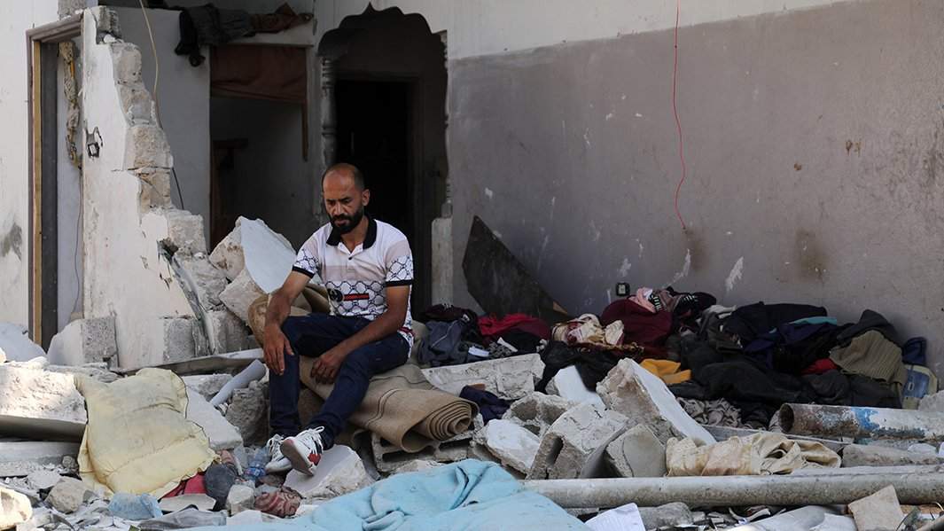 Палестинец смотрит на руины здания в Джебалии