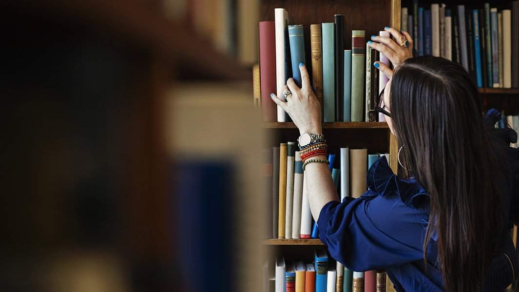 Девушка выбирает книги в книжном магазине