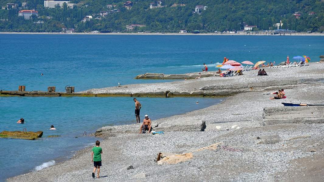 Отдыхающие на пляже в городе Гагры в Абхазии