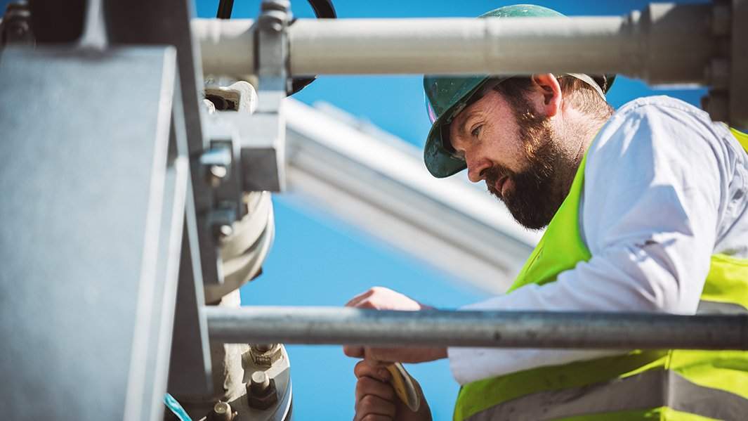 Специалист работает на территории газораспределительного центра магистрального газопровода