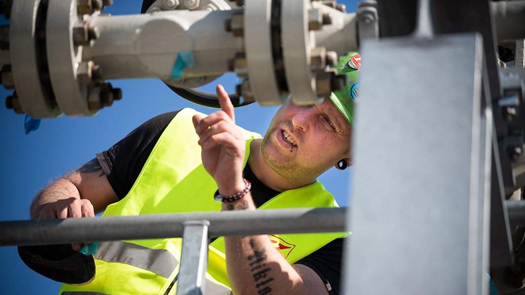 Специалист работает на территории газораспределительного центра магистрального газопровода