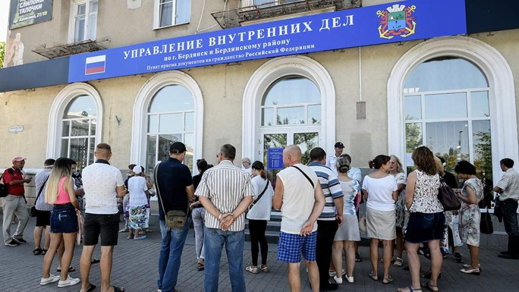 Жители Бердянска стоят в очереди у входа в пункт приема документов на гражданство Российской Федерации