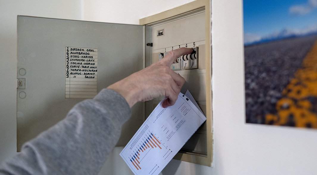 мужчина выключает лампочки со счетом за электроэнергию